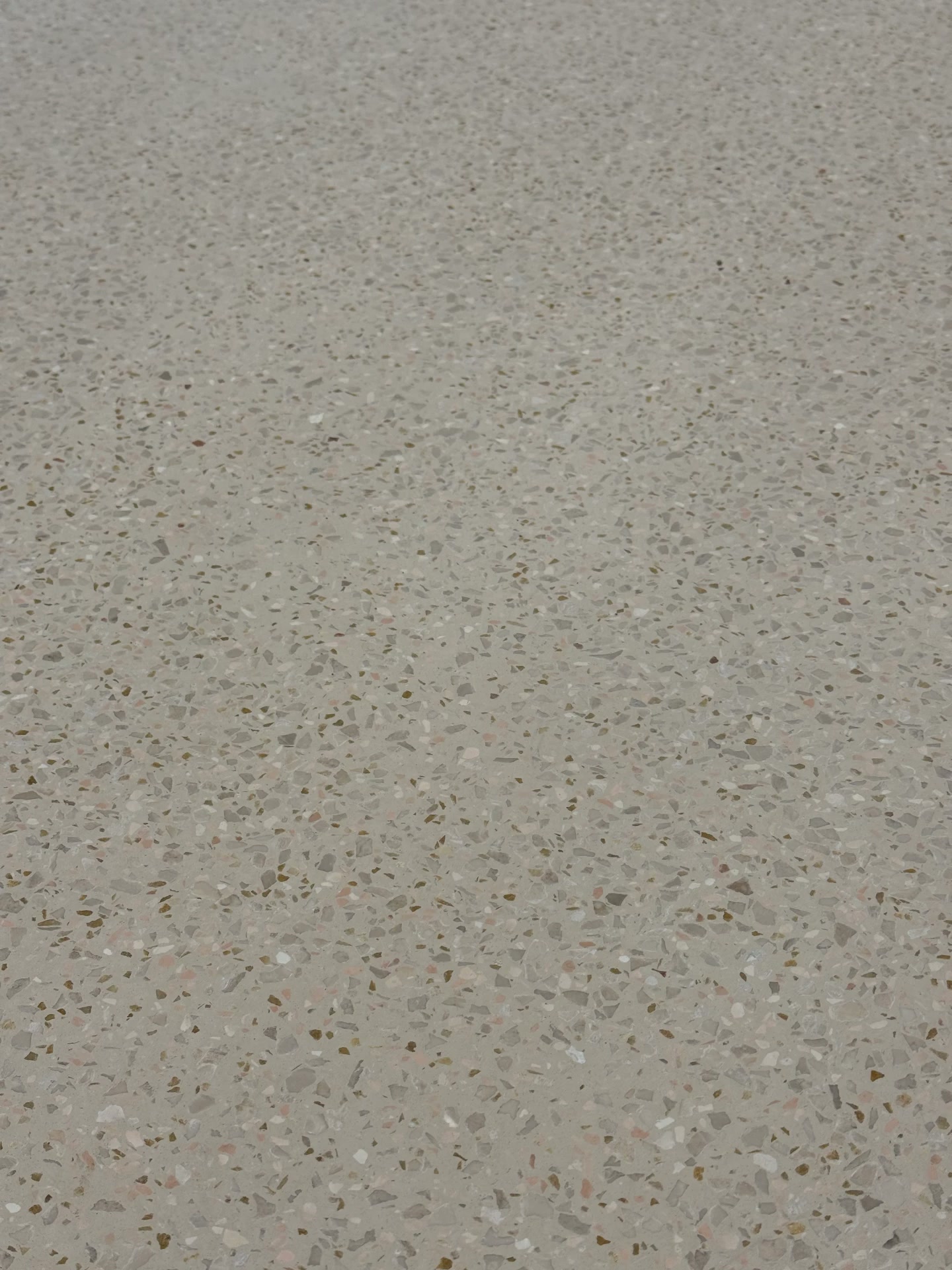 Close-up detail of the polished terrazzo aggregate surface at Zaventem Airport