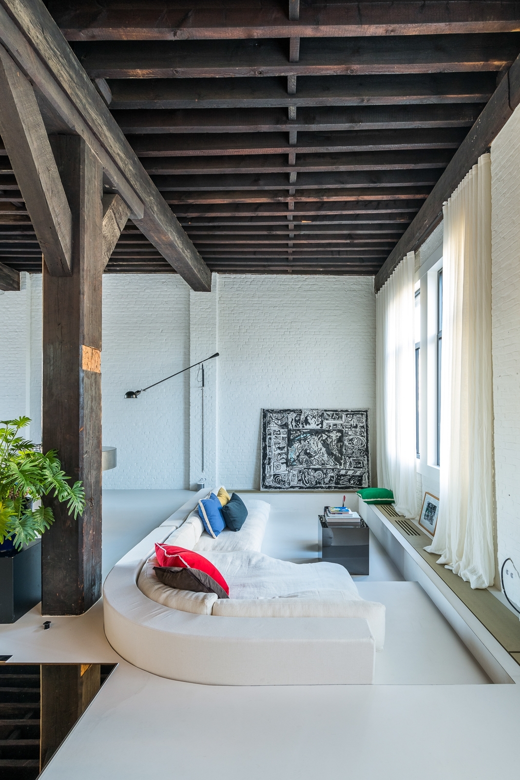 Living area of Coffee Roastery Loft with a seamless mineral floor and exposed timber frame